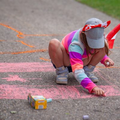 Youngster drawing flag in chalk, Canada Day, Kinsmen Park, Strathmore, AB, 2026-07-01