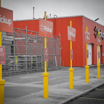 Walmart pickup area, orange signage in a black and white photo.